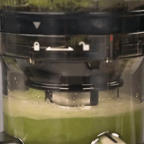 Close-up of an auto8 juicer with green grounds inside
