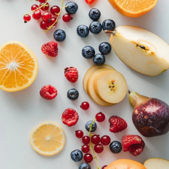 Kuvings fresh juice ingredients with oranges, apples, pears and berries on a white background for homemade juice recipes.
