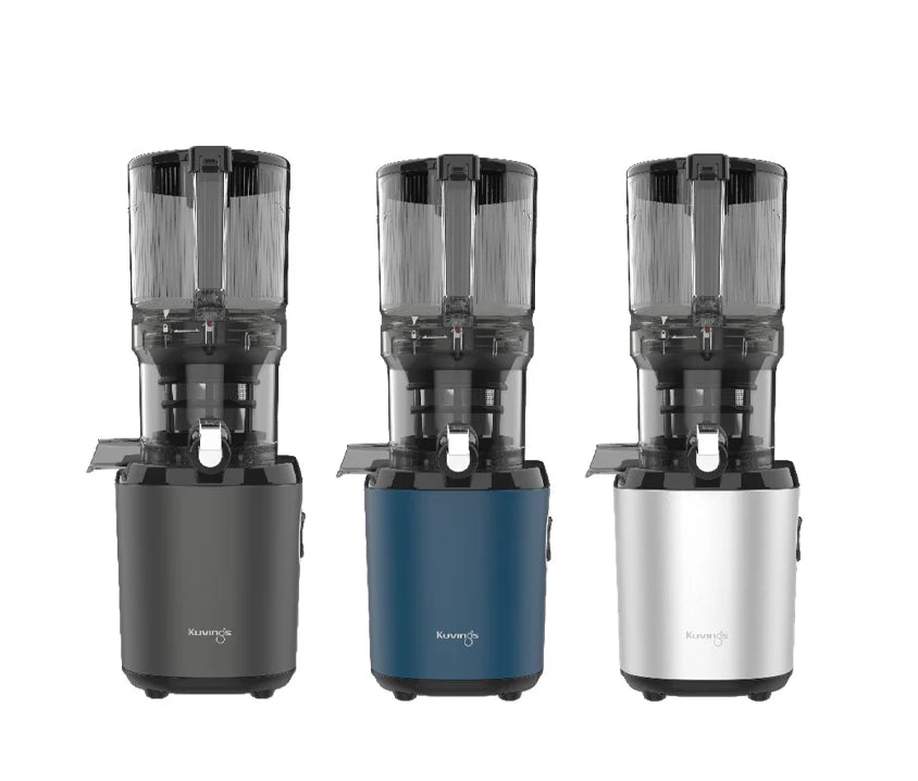 Straight-on studio product shot displaying the three color options of the Kuvings AUTO6 whole slow juicer side-by-side in graphite grey, navy blue, and silver with mega-hoppers attached against a white background.