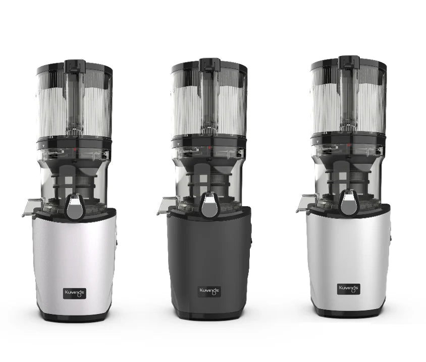 Straight-on studio product shot displaying three color options of the Kuvings AUTO8 whole slow juicer side-by-side in white, dark graphite grey, and silver with large auto-hopper containers attached against a white background.