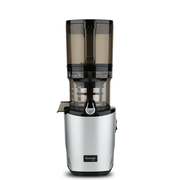 Straight-on studio product shot of a silver Kuvings AUTO8 whole slow juicer featuring a transparent grey mega-hopper and a visible measuring scale on the juicing bowl, isolated against a transparent grid background.