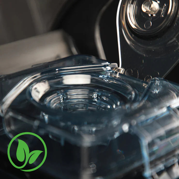 Close-up view of the transparent lid and vacuum valve mechanism of a Kuvings CB1000 vacuum blender, featuring a green leaf icon overlay in the bottom-left corner.