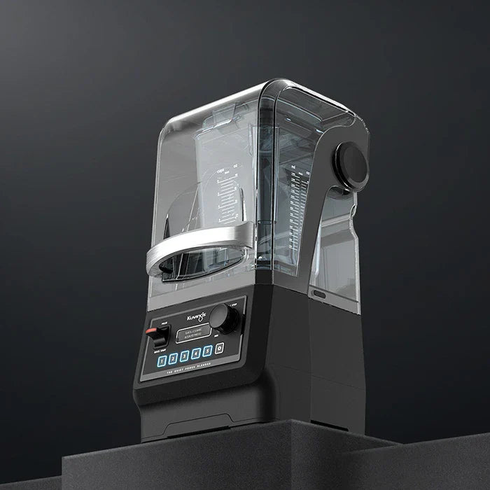 Low-angle, three-quarter view of the Kuvings CB850 commercial quiet power blender with its clear soundproof enclosure shield closed, showcasing the full unit on a dark studio background.