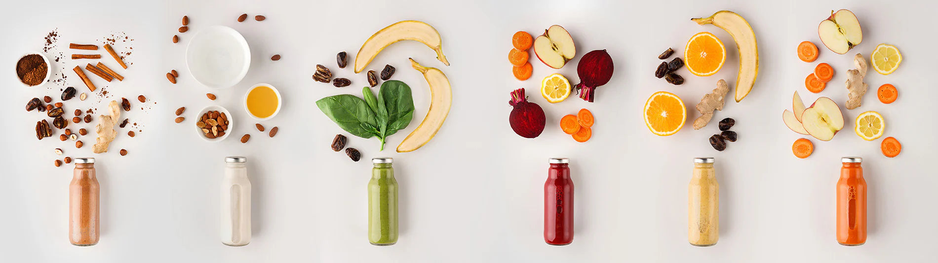 kuvings cold pressed immune booster with fruit nuts and juice bottles arranged.