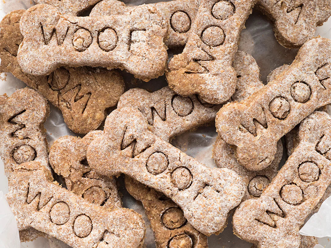 Dog treats shaped like bones with 'WOOF' embossed on them made with kuvings pulp