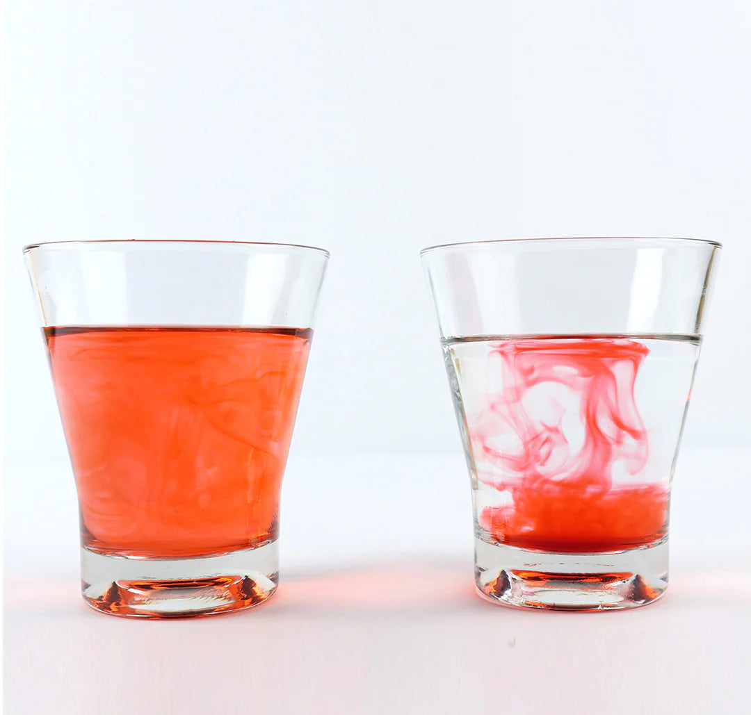 Two glasses with red liquid on a white background