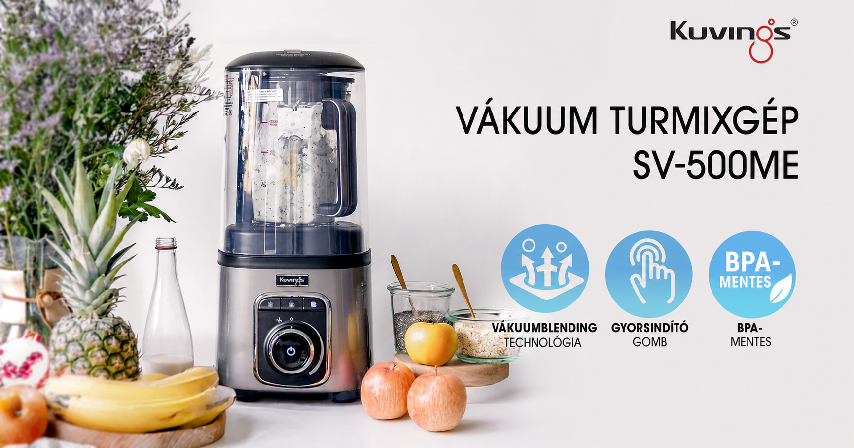 Frontalansicht eines Marketingbanners für den Kuvings SV-500ME Vakuum-Standmixer, der das Gerät auf einer weißen Oberfläche zeigt, umgeben von frischem Obst, einer Flasche und Gläsern mit Samen, begleitet von ungarischem Text und drei blauen Symbolen, die seine Hauptmerkmale hervorheben.